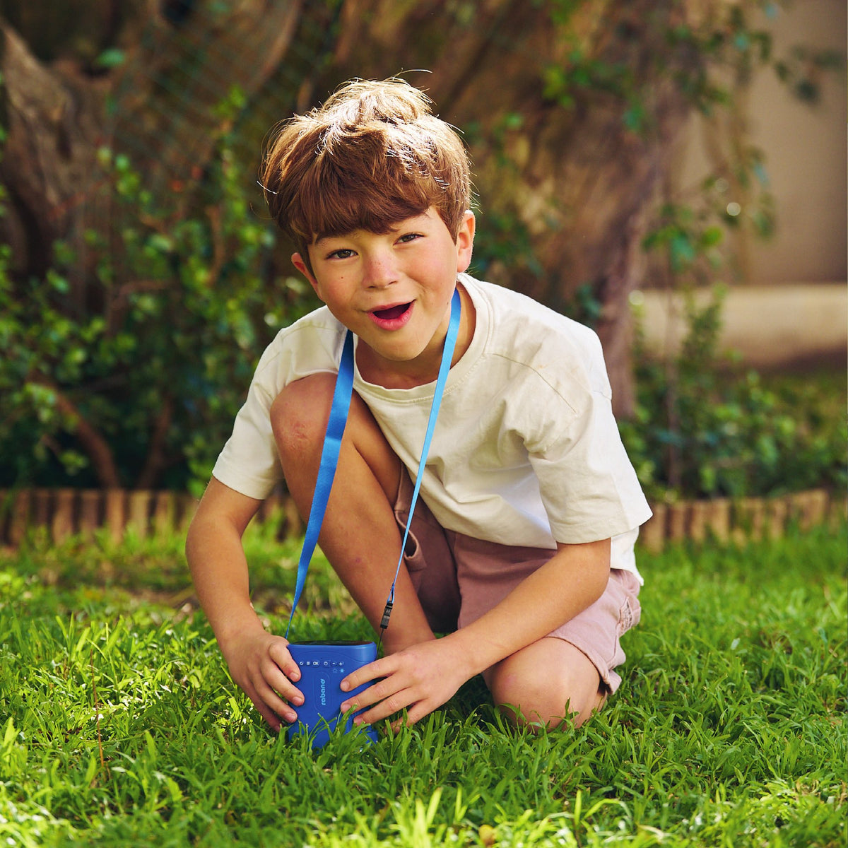 Junge mit Kindermikroskop im Garten